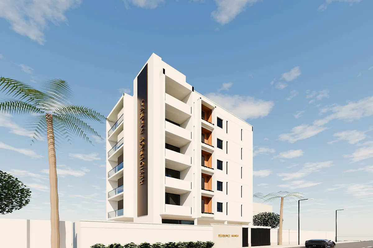 Résidence Mansa de jour : façade blanche, balcons vitrés et palmiers