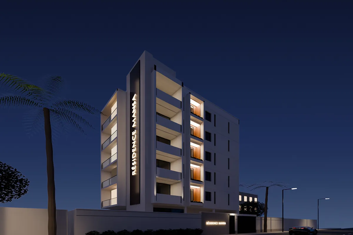 Résidence Mansa de nuit : immeuble R+5 aux balcons éclairés et enseigne verticale