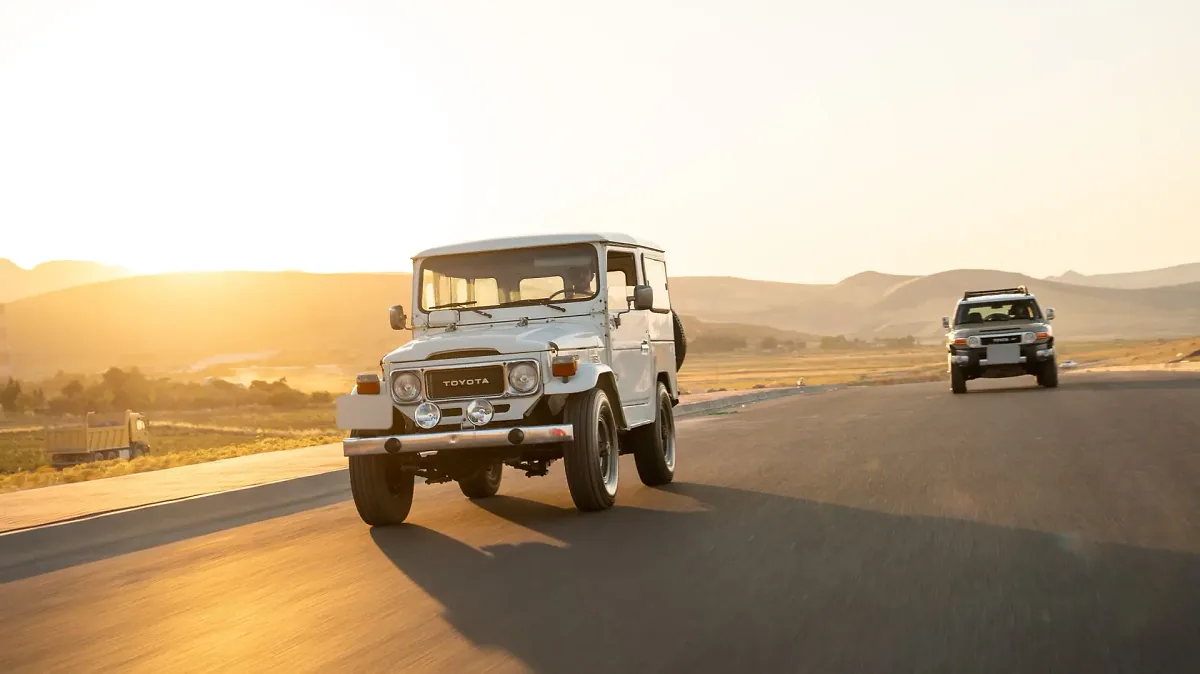 Toyota Land Cruiser ancien modèle sur la route au coucher du soleil