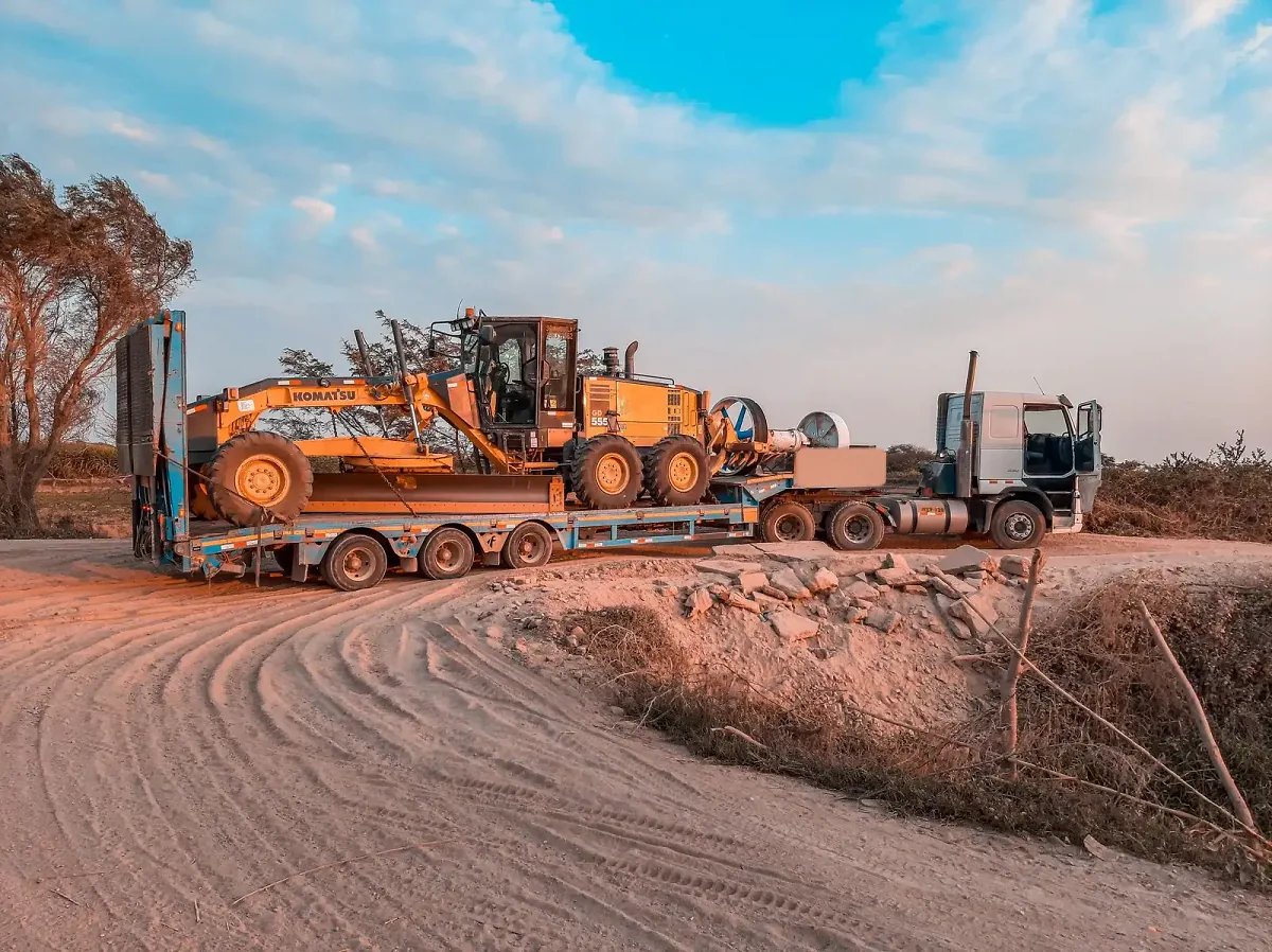 Porte-engins transportant une niveleuse